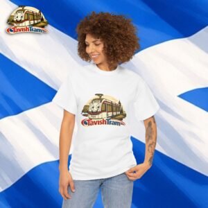 White T-shirt with a Tavish Tram cartoon tram print worn by a smiling person, blue and white diagonal backdrop behind her.
